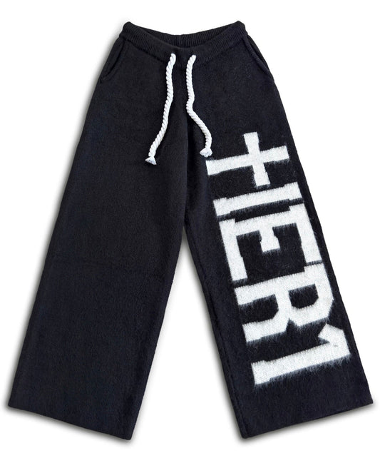 Black sweatpants with 'HER1' text on a white background
